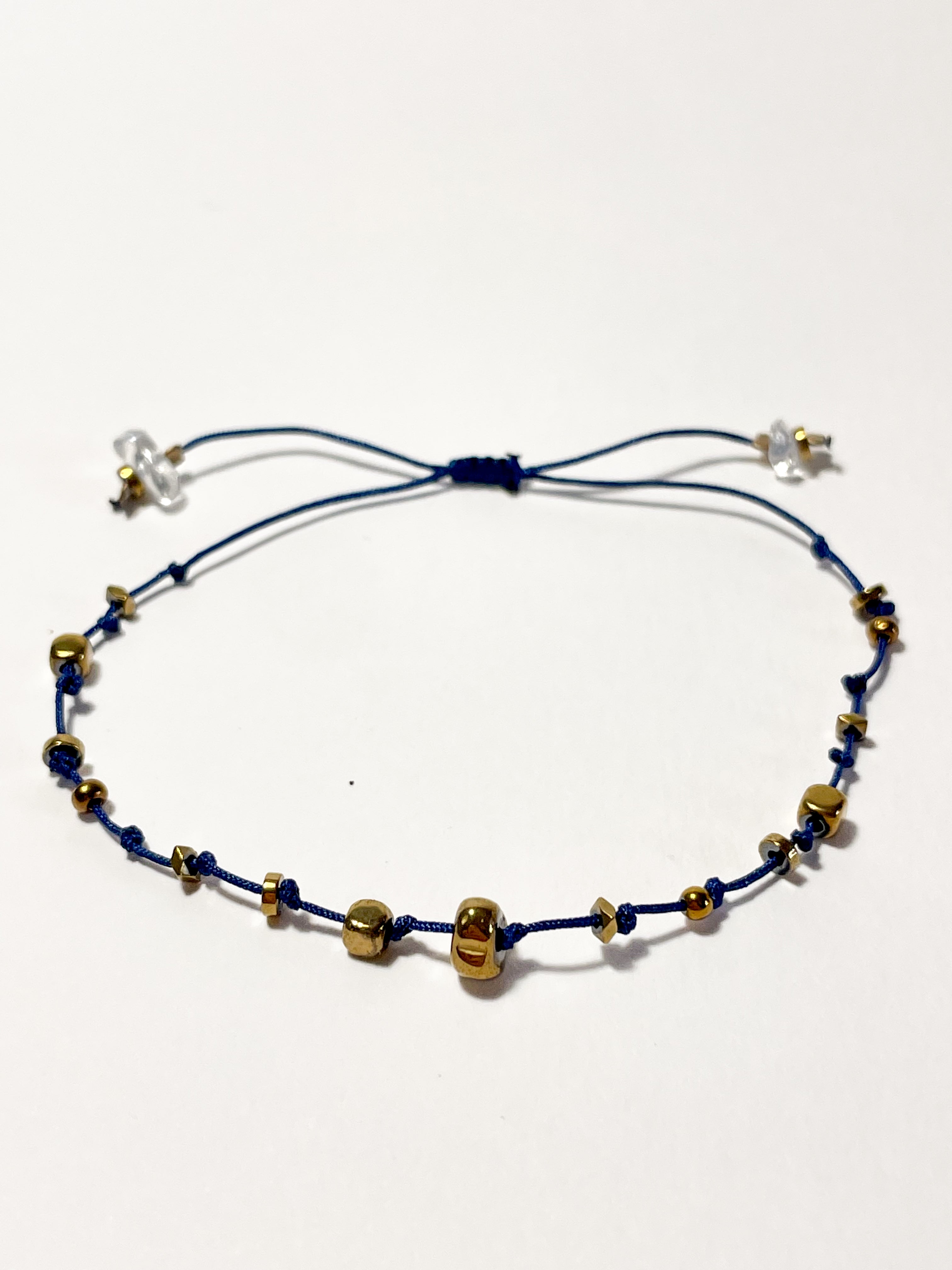 bracelet fin en hematite dorée, noeud coulissant bleu foncé