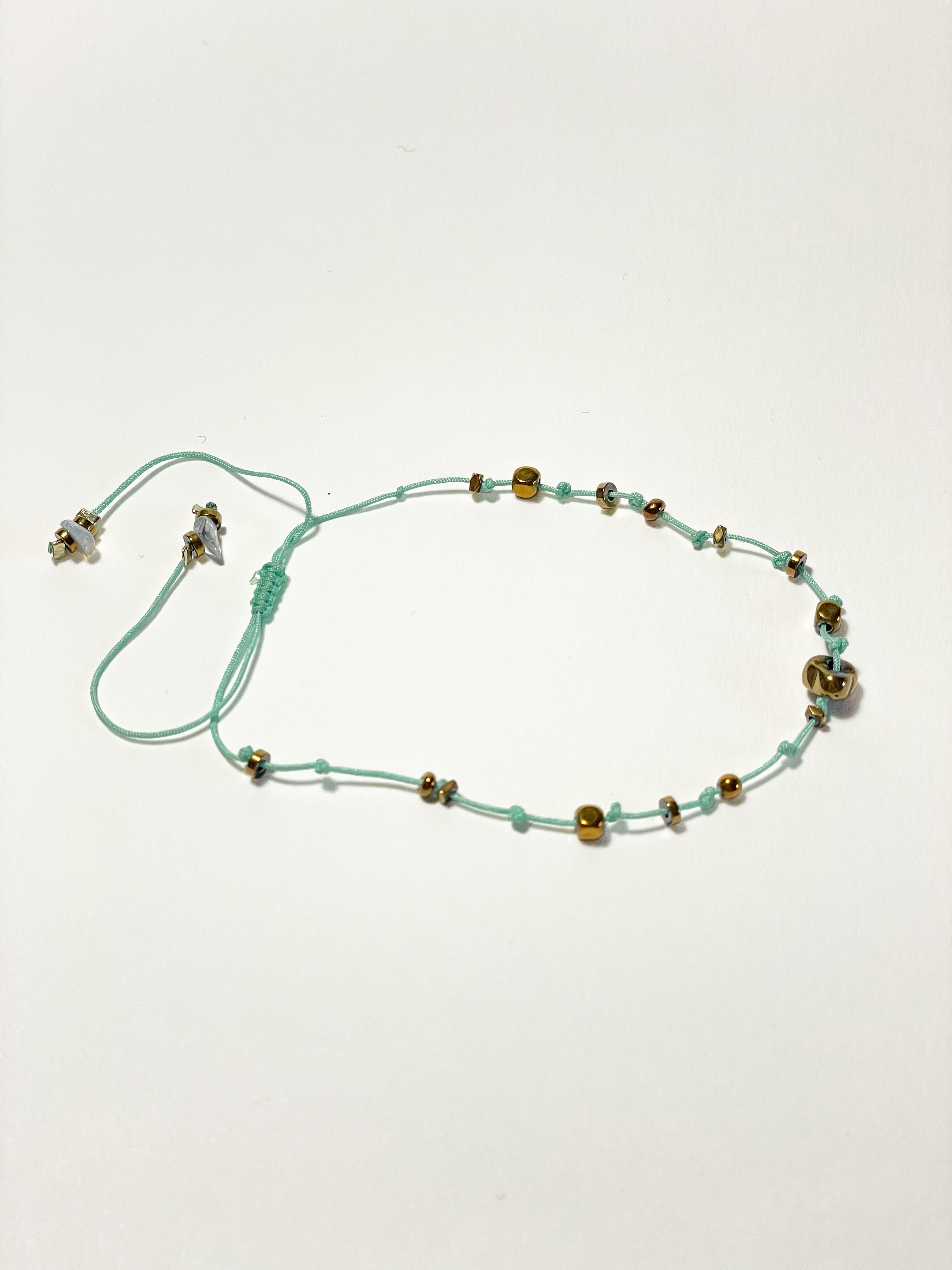 bracelet fin unisexe en hematite dorée, noeud coulissant céladon