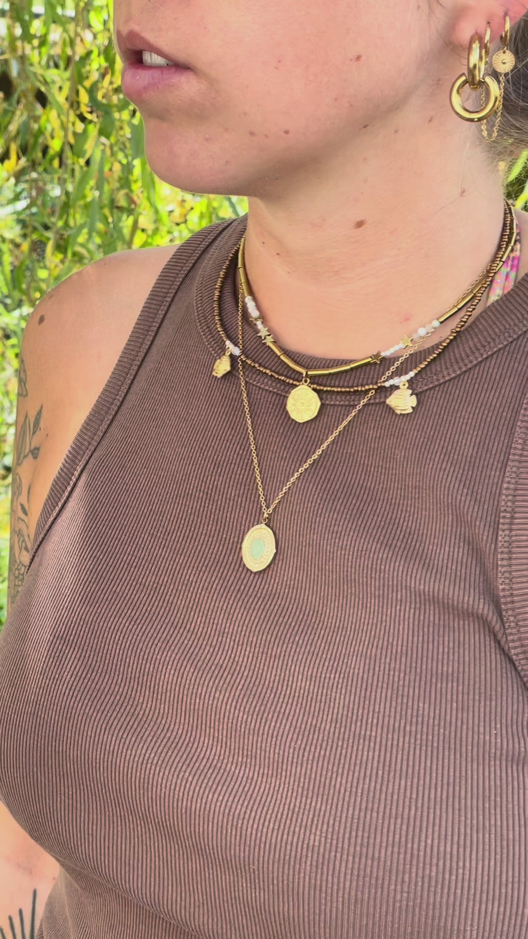 Collier multi-rangs doré et blanc avec breloques porté 