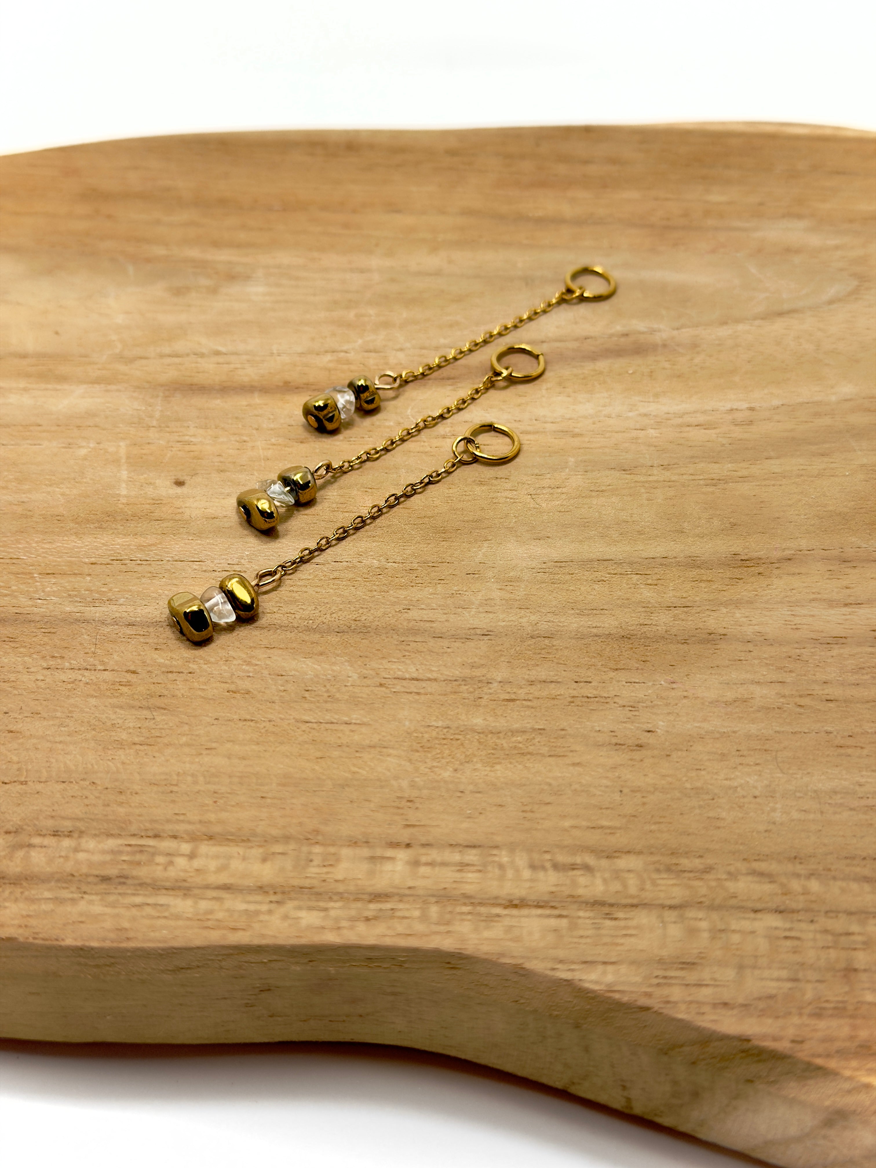 Zoom sur breloque faite main en acier inoxydable et pierres naturelles, hématites dorées et opal cristal 